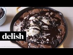 a skillet filled with chocolate and ice cream next to a bowl full of cookies