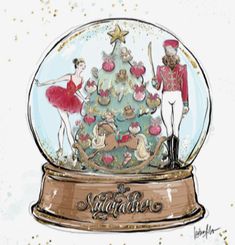 a snow globe with a ballerina and nutcracker in front of the tree