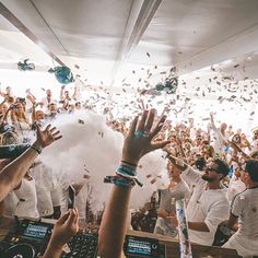 a group of people throwing confetti into the air in front of a crowd