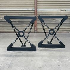 two black metal stands with chains on them