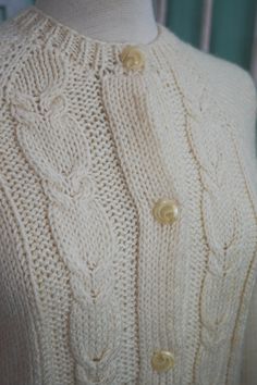 A classic women's cardigan sweater, in a soft ivory white acrylic. It has a unique wide pattern of traditional cable knit down the front. It closes up the front with a row of really unique swirly plastic buttons. The sweater is soft and comfy, not stiff at all. No damage or issues. Please check measurements carefully. Condition: Very Nice Vintage Tag: 100% Acrylic Size L Measurements in inches.... Length: 23.5 Chest: 19 ✩ Because you don't want to miss a thing, follow @heartkeyologie on Facebook Elegant Cream Cable Knit Outerwear, Elegant White Cable Knit Cardigan, Classic Cream Cardigan With Buttons, Elegant Cream Cable Knit Cardigan, Fitted Classic Cardigan In Winter White, Classic Fitted Winter White Cardigan, Classic Fitted Cable Knit Cardigan, Fitted Classic Cable Knit Cardigan, Classic Knit Cardigan For Winter