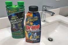 two bottles of drain cleaner sitting on top of a sink next to a faucet