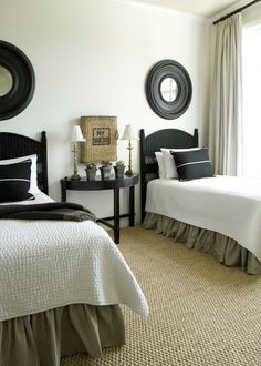 two beds in a bedroom with black and white decor