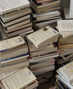 a pile of books sitting next to each other on top of a carpeted floor