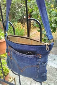 an old pair of jeans hanging from a metal rack with the bottom pocket open and zipper undone