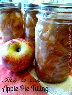 three jars filled with apple pie filling sitting on top of a table next to an apple