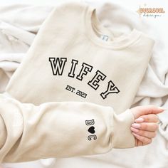 a baby wearing a sweater with the word wife printed on it