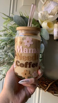 a hand holding a mason jar with a straw in it that says mama needs coffee