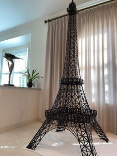 a model of the eiffel tower is shown in front of a curtained window