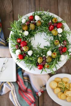 a white plate topped with olives and feta cheese wreath on top of a wooden table