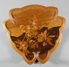 a wooden plaque with flowers painted on it