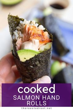 someone is holding up a sushi roll with salmon and avocado