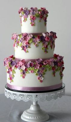 a three tiered cake with pink and purple flowers on it