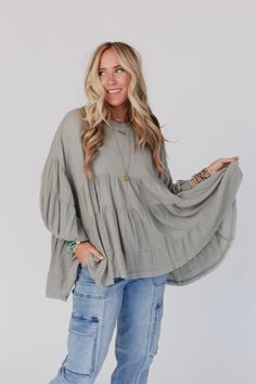 Fun and flowy, the In The Clouds Tunic Top will keep you comfortable and confident all day long! Once you put this top on, you wont want to wear anything else because it features: Lightweight and flowy fabric Relaxed, oversized silhouette Classic rounded neckline Multiple gathered tiers throughout for the cutest silhouette Long puff sleeves with gathered elastic wrists Keyhole button back closure So cute comfy boho outfit pair with: Floral Textured Padded Bralette, Cher Solid Raw Edge Flare Pant Effortless Oversized Top For Layering, Spring Cotton Tops With Loose Fit, Flowy Cotton Tops For Loungewear, Casual Tunic Top For Loungewear, Loose Fit Cotton Top For Spring, Versatile Oversized Top For Spring, Oversized Versatile Tops For Spring, Billowy Cotton Top For Day Out, Flowy Blouse For Spring Loungewear