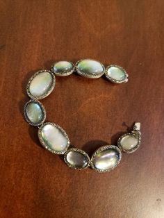 "Truly elegant and still cool! Ovals alternate sizes of larger 22x17mm and smaller 17x13mm. 7 1/4\" length, 11/16\" at widest point; Hidden box-insert clasp; NATURAL Gray Mother-of-Pearl ovals that are topped with Clear Quartz for protection, and framed by Marcasite for SPARKLE☺ The gray Mother-of-Pearl shows all the colors of silver, pink, and pistachio green. Hallmarked SLC 925 THAILAND *Brand New* Contact me with any questions" Oval Cabochon Bracelets For Formal Occasions, Elegant Iridescent Bracelet Jewelry, Oval Mother Of Pearl Gemstone Jewelry, Silver Oval Beads Jewelry For Formal Occasions, Formal Silver Jewelry With Oval Beads, Oval Cabochon Bracelet For Wedding, Oval Cabochon Wedding Bracelet, Elegant Iridescent Oval Jewelry, Silver Oval Mother Of Pearl Jewelry