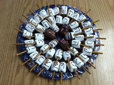 a blue plate topped with marshmallows and chocolate covered pretzel pops