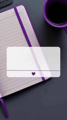 a notepad with a heart on it next to a cup of coffee