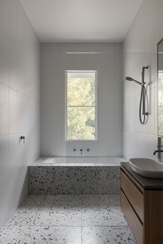 a bathroom with a sink, bathtub and window in the middle is shown here