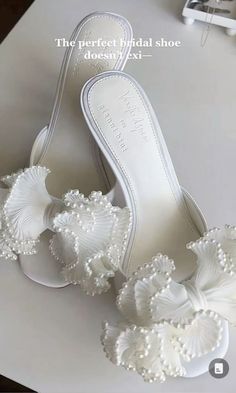 a pair of white shoes with pearls on them