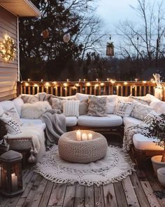 a white couch sitting on top of a wooden floor next to a table filled with candles