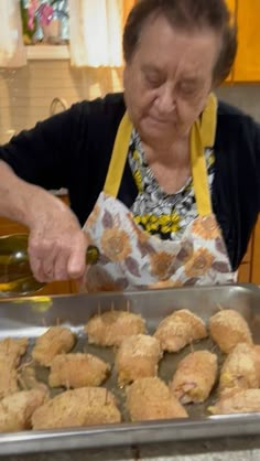 an older woman is preparing food in the kitchen