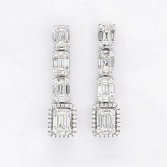 Keep them dazzled, with these ultra elegant diamond cluster baguette and round cluster earrings. Refine your look with the elegant glow of these dangling diamond cluster dangle drop earrings. Revisit elegance with cascading graduating clusters, shimmering with brilliant diamonds, skillfully set on these ultra-glamorous linear drop earrings. Metal: 18KT White Gold Weight:7.30 Grams Gemstones: Natural Diamonds Number of Diamonds:122 Shape: Round/ Baguette Total carat Weight: 1.16CT Setting: Pave/ Luxury Diamond White Gemstone Earrings, Luxury Cluster Earrings In Diamond White, Luxury White Gold Gemstone Cluster Earrings, Luxury Diamond White Cluster Drop Earrings, Diamond Earrings Studs Round, Earrings Luxury, Dangler Earrings, Luxury Diamonds, Earrings Metal