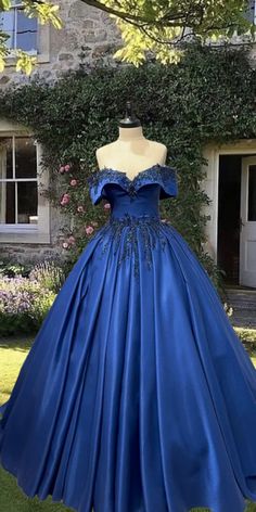 a blue ball gown on display in front of a house