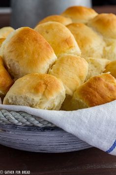 a basket filled with rolls sitting on top of a wooden table