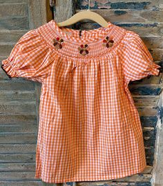 Adorable Thanksgiving smock dress. 100% cotton. Machine wash, lay flat to dry. Fits true to size. Please refer to size chart in item's pictures. :) Our smocks are made by a trusted partner within the USA. Ships within 1-3 business days.  Arrives 1-5 business days after shipped. If need it sooner, please message us, and I can send you an upgrade for shipping. Cotton Smocked Short Sleeve Dress For Daywear, Cotton Short Sleeve Smocked Dress For Daywear, Short Sleeve Gingham Smock Dress, Cotton Gingham Smocked Dress With Ruffles, Short Sleeve Gingham Smocked Dress, Casual Cotton Smocked Dress With Smocked Cuffs, Cotton Smocked Dress With Ruffles In Gingham, Fitted Cotton Smocked Dress, Short Sleeve Cotton Top With Smocked Cuffs