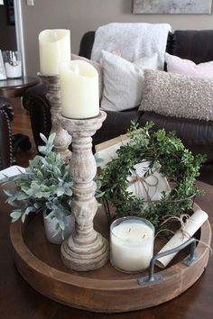 a tray with candles, wreaths and other items on it in a living room