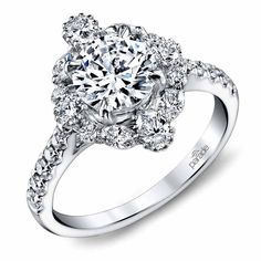 a diamond engagement ring with an intricate halo setting on the center and side stones around the band