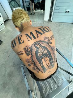 the back of a man's upper half with an image of jesus and mary on it