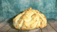 a pie sitting on top of a wooden table next to a blue wall and floor