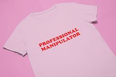 Professional Manipulator T-Shirt | Funny Tee | Y2K Shirt | Graphic Shirt | Gift for Girlfriend | T Shirt | Y2K Unisex Tee | Funny Shirt Unisex Comfy T-Shirt to Lounge in! Actual item may be lighter/darker than pictured. M A T E R I A L S - 100% RING SPUN COTTON - Regular Fit - Shoulder Taping - Unisex S I Z I N G - Size chart is available on our listing photos. S H I P P I N G  &  P R O D U C T I O N  T I M E - Production Time is 2-3 Business Days. (May be delayed during the Holiday Season) - Sh 90s Slogan T-shirt In Pink, Pink Band Merch T-shirt With Logo Print, Y2k Slogan Shirt For Streetwear, 90s Style Pink T-shirt With Text Print, Pink Y2k Shirt For Streetwear, Pink Y2k Style Shirt For Streetwear, Pink Y2k Streetwear Shirt, Pink Band Merch Shirt With Screen Print, 90s Slogan Pink T-shirt