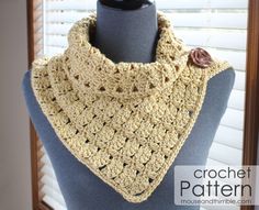 a crocheted cowl with a flower on the end is sitting on a mannequin