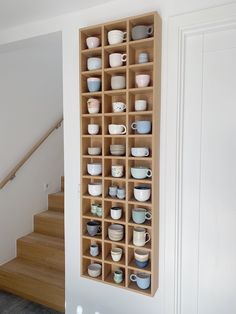 a wooden shelf filled with cups and saucers on top of a hard wood floor