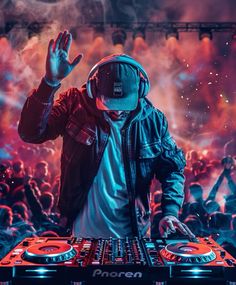 a dj mixing music in front of a large group of people with their hands up