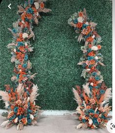 two floral arrangements are arranged in front of a green wall with white and orange flowers