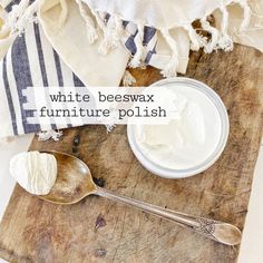 white beeswax furniture polish on a cutting board next to a spoon and towel