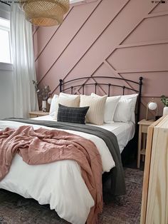 a bed room with a neatly made bed next to a window and a night stand