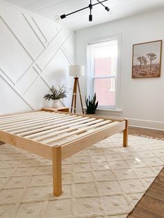 a bedroom with a bed frame made out of wooden slats and a rug on the floor