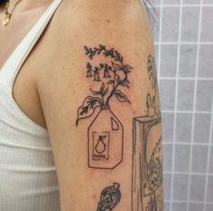 a woman with a tattoo on her arm has a jar and flowers in it that says love