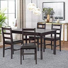 a dining room table and chairs with a rug on the floor