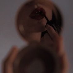 the reflection of a woman's hand holding a brush in front of her face