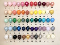 a large number of balloons are arranged on a wall with the numbers in different colors