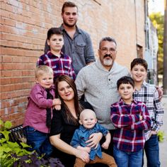 a family posing for a photo in front of a brick wall