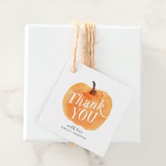 a thank you card with an orange painted on it and twine around the tag