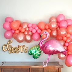 a flamingo balloon and some balloons on a wall