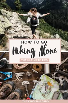 a woman standing on top of a mountain with her arms outstretched in the air, surrounded by hiking gear