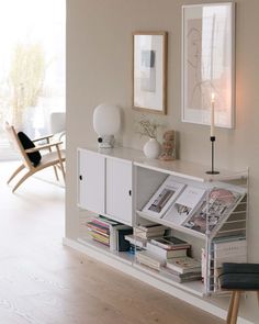 a white shelf with books and magazines on it